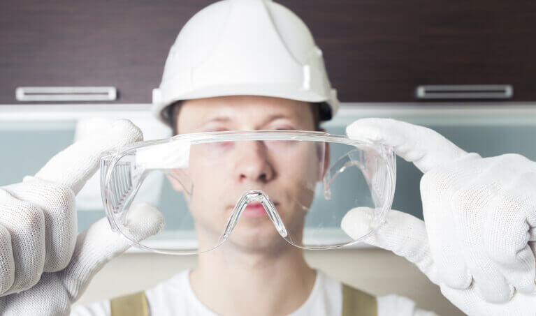 Worker holding up a pair of over-prescription safety glasses