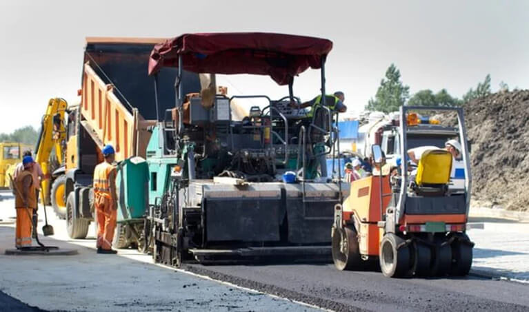 Road workers laying asphalt