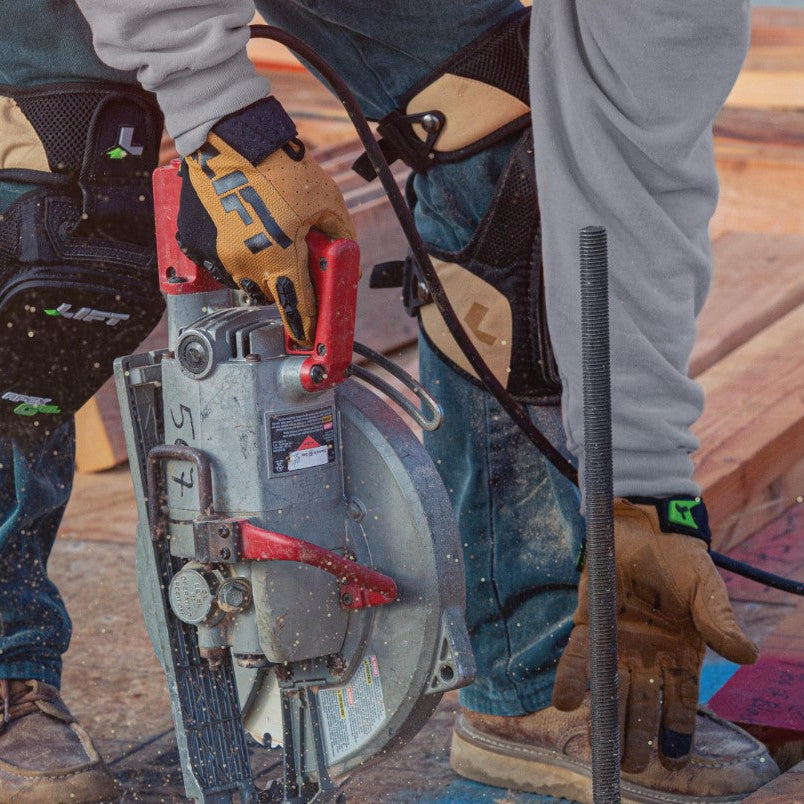 Construction worker wearing LIFT Safety Trader Work Gloves while operating a saw.