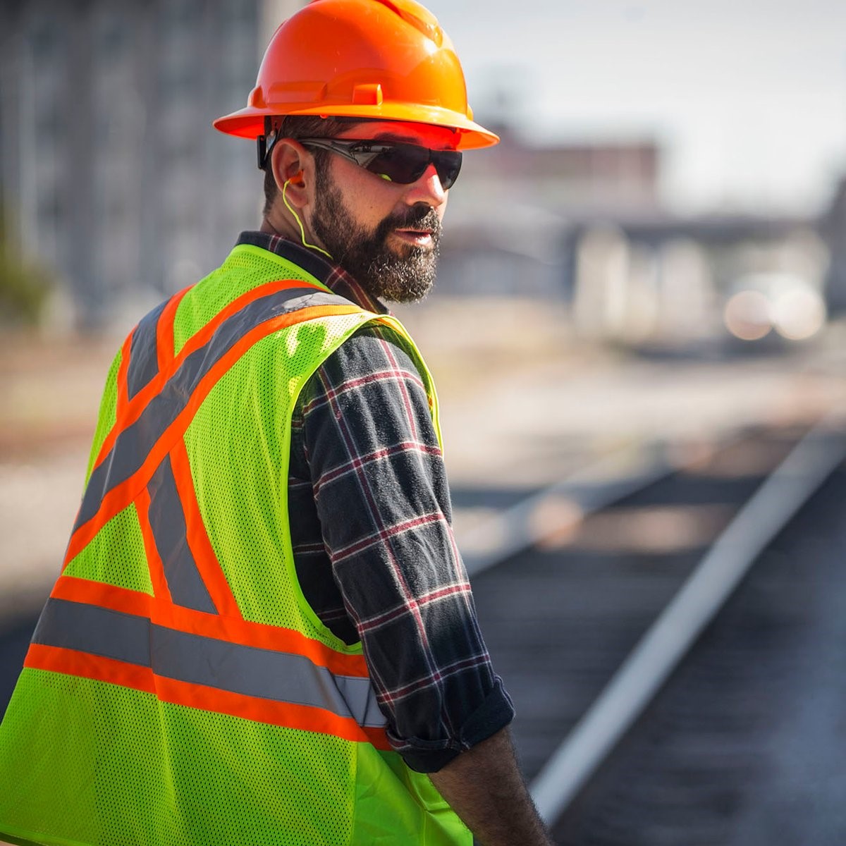 Pyramex Endeavor Plus Safety Glasses with Black Frame and Gray Anti-Fog Lenses, worn by a worker with an Orange hard hat