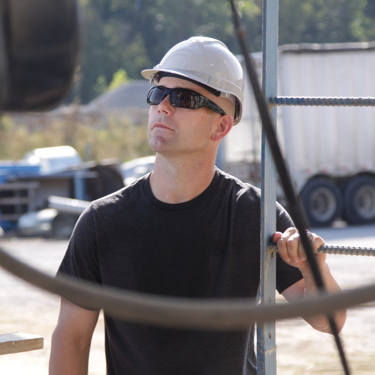 Pyramex Furix Safety Glasses with Black Frame and Gray Anti-Fog Lenses worn by worker with a white hard hat