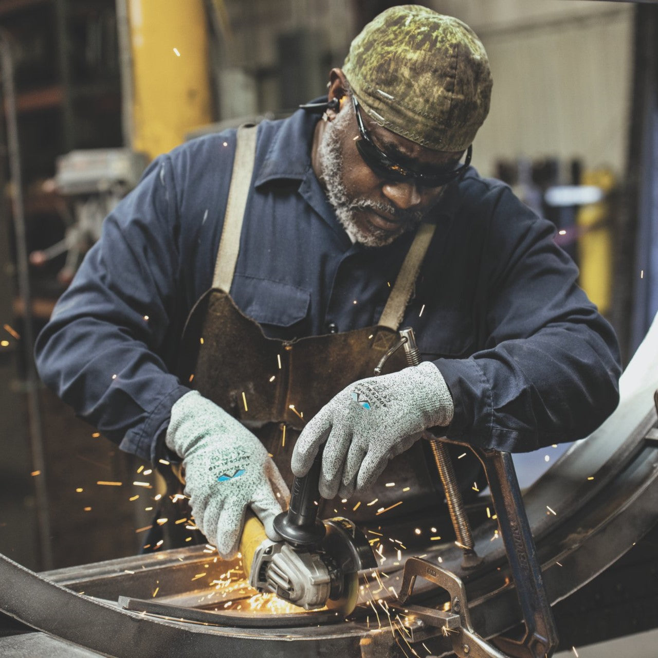 Pyramex GL402C5 Polyurethane Cut-Resistant Work Gloves with ANSI Cut-Level 4, worn while cutting metal