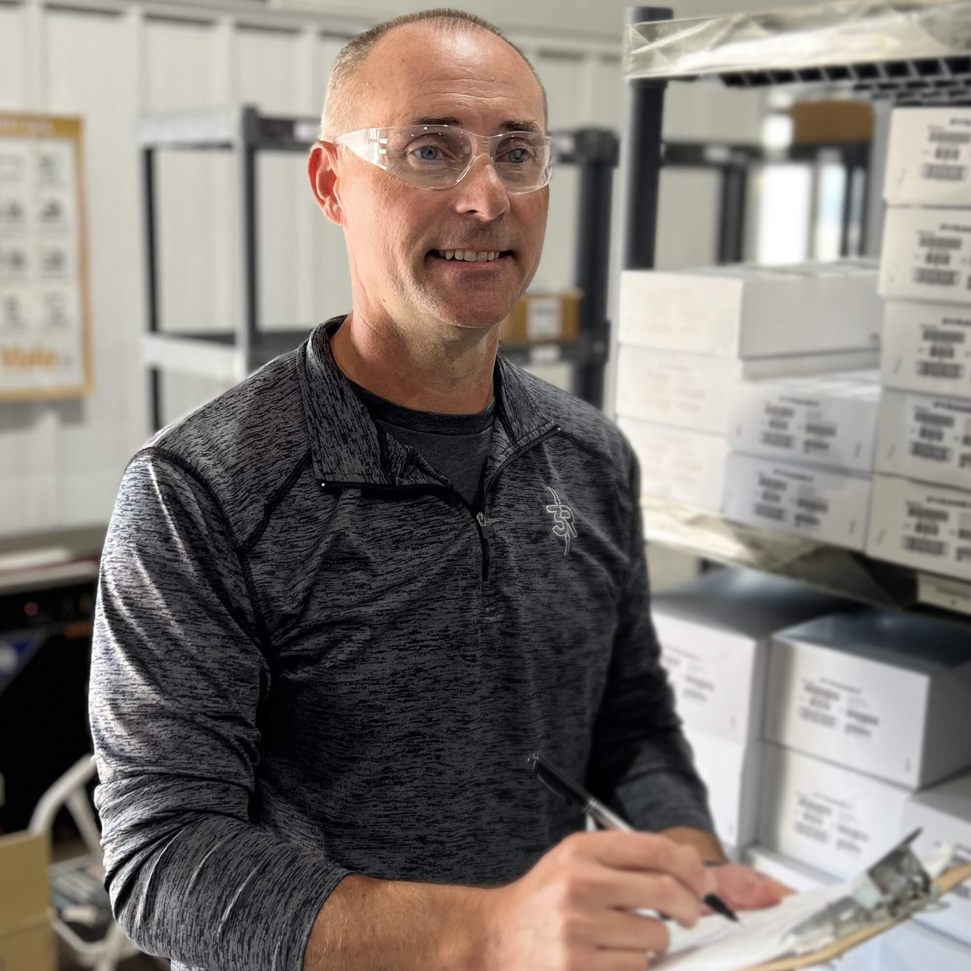 Warehouse worker checks inventory while wearing Pyramex S4110R Intruder Readers Bifocal Safety Glasses with Clear Lenses