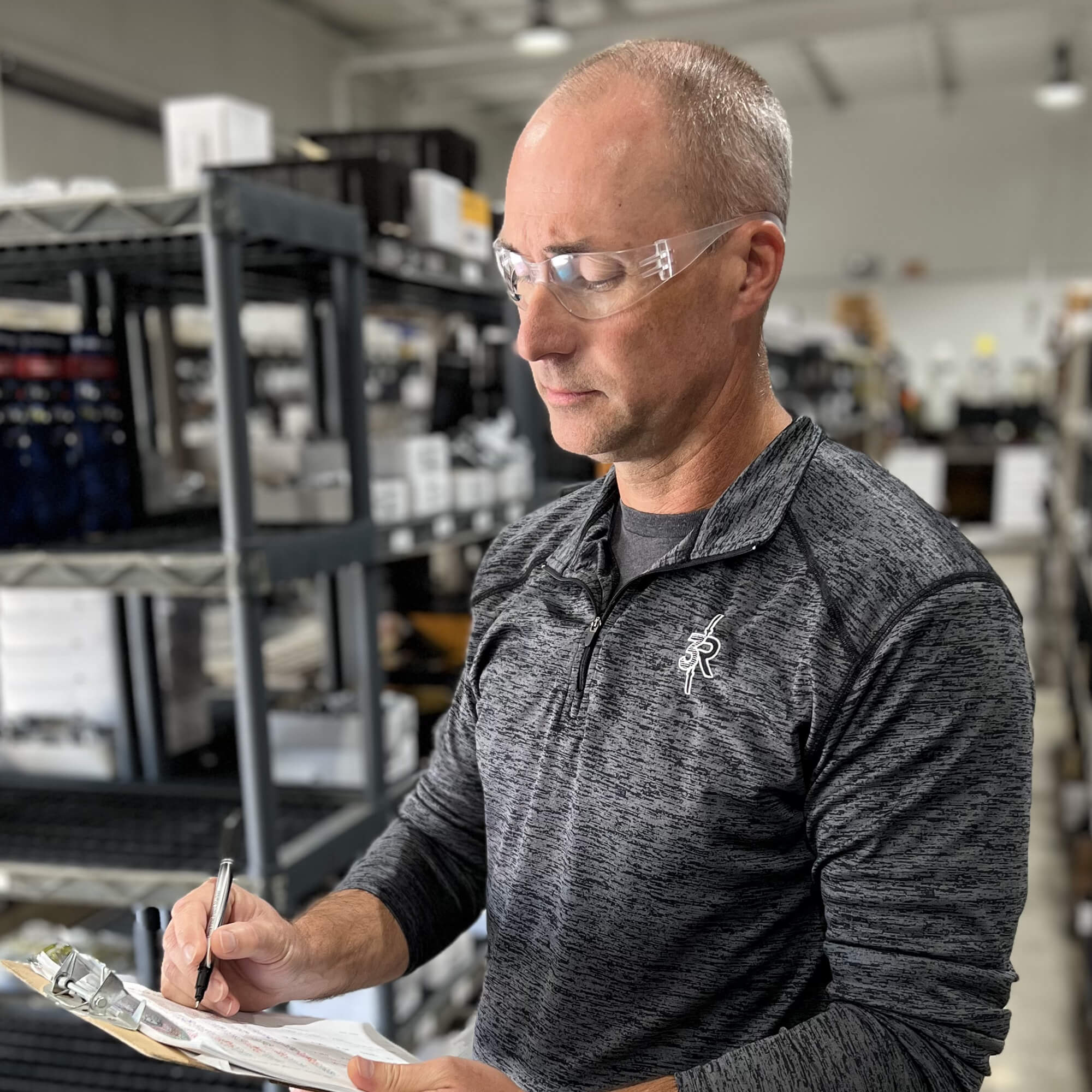 Pyramex S4110R Intruder Readers Bifocal Safety Glasses with Clear Lenses worn by warehouse worker reading inventory documents