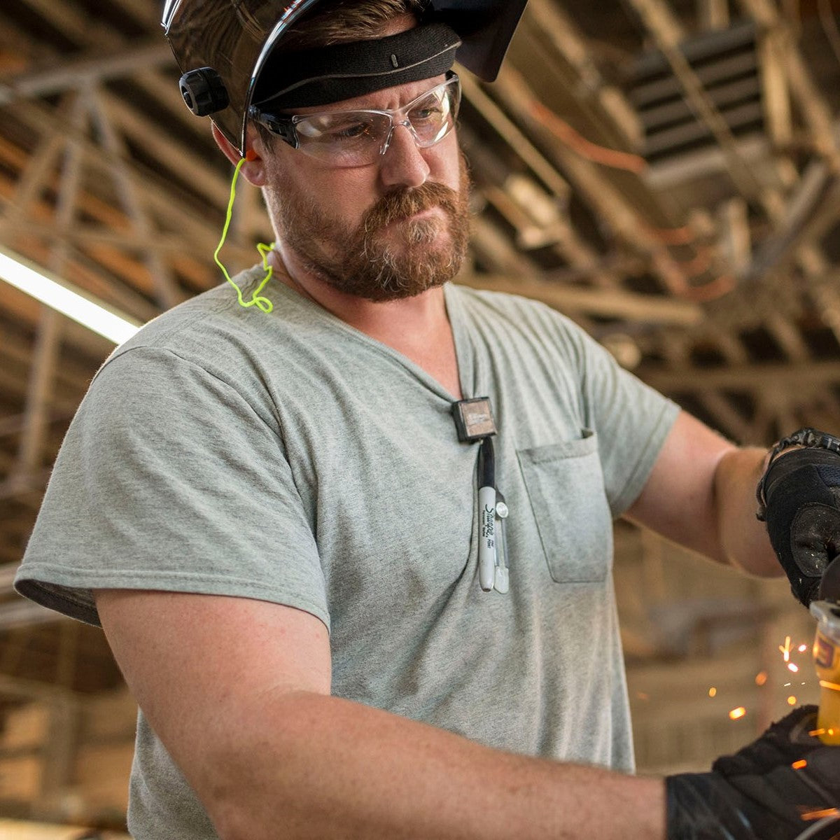 Pyramex Trulock Safety Glasses with Clear Lenses worn by worker grinding metal