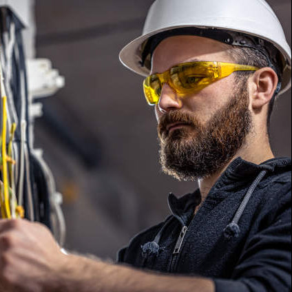 Worker wearing Radians Mirage Safety Glasses with Amber Lens and a white hard hat
