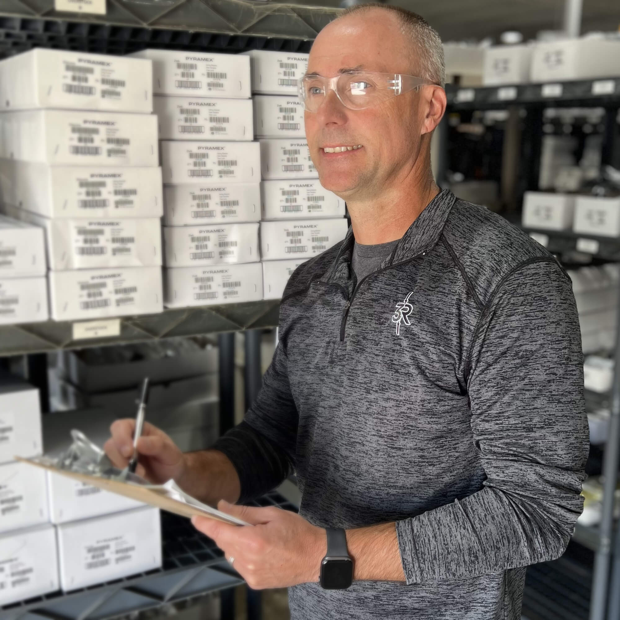 Warehouse worker wearing Pyramex S4110R Intruder Readers Bifocal Safety Glasses with Clear Lenses while checking inventory