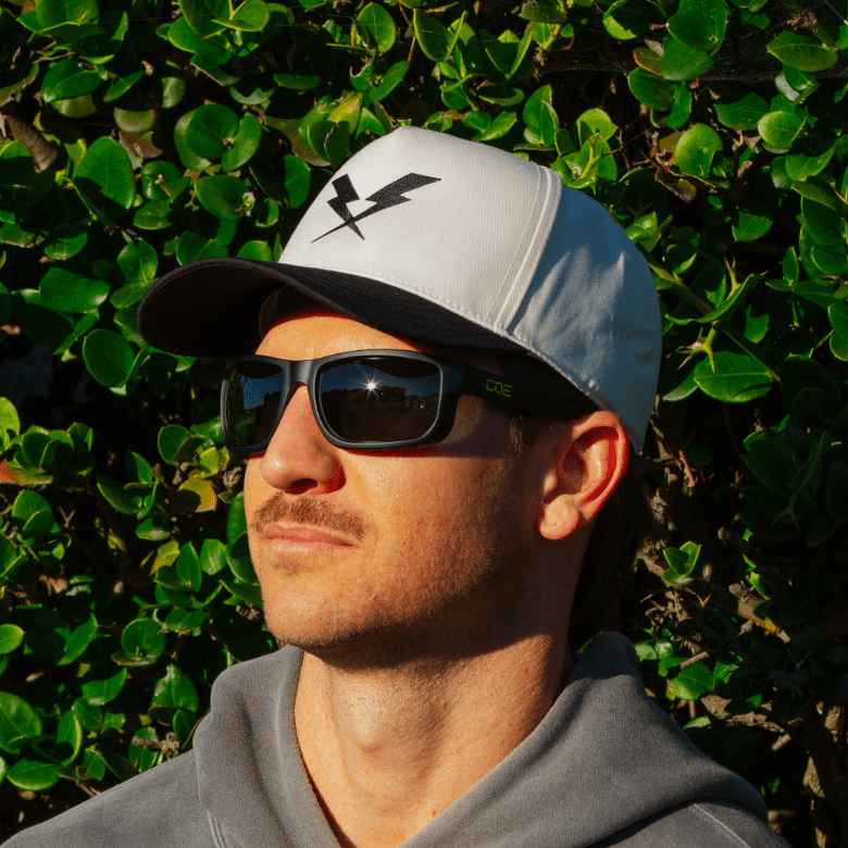 CO Eyewear Magneto Z87+ safety glasses with matte black frame on a man wearing a white and black hat.