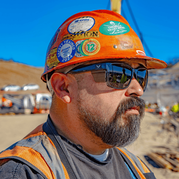 CO Eyewear Oiler Z87+ Safety Glasses with Gray Frame with Smoke Lenses worn by construction worker with a hard hat