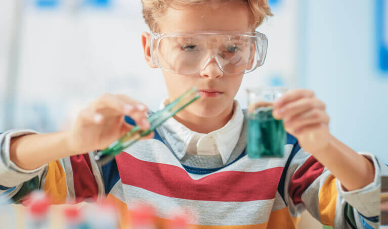 Student wearing safety goggles while performing a lab experiment