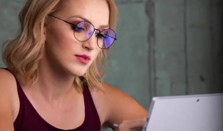 Woman wearing computer eyewear while using a laptop