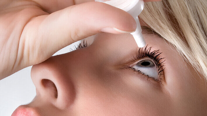 Woman using eye drops to help with dry eye symptoms