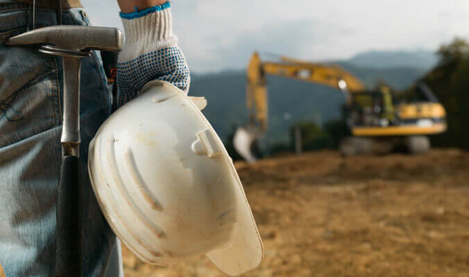 Construction worker carrying a hard hat