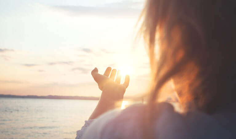 Woman watching the sunset on the beach