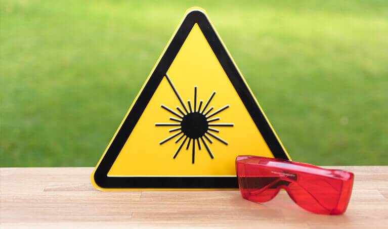 Laser Safety Glasses next to a Laser Warning Sign