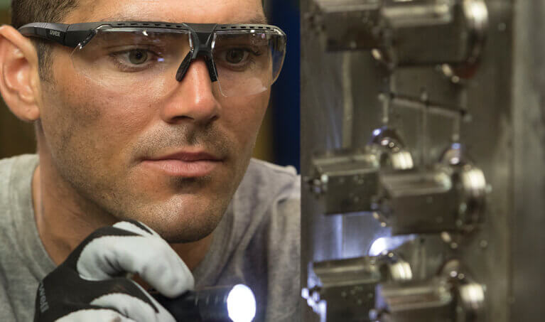 Worker operating machinery wearing safety glasses