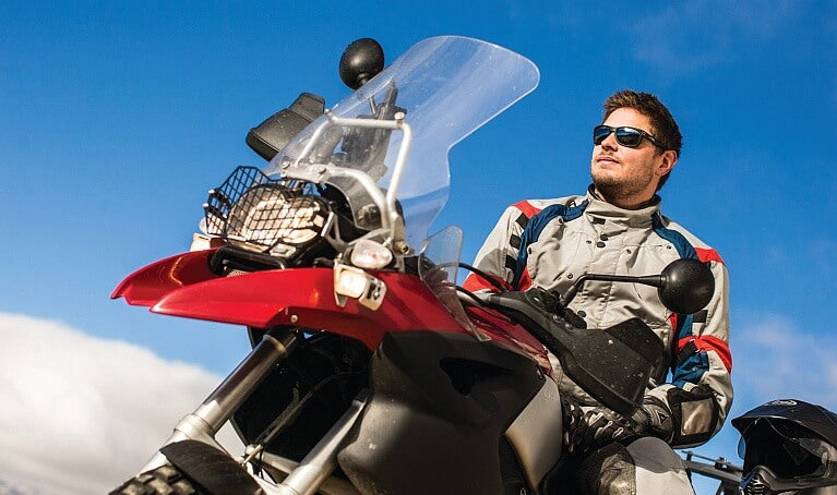 Motorcycle rider wearing sunglasses while taking a quick break