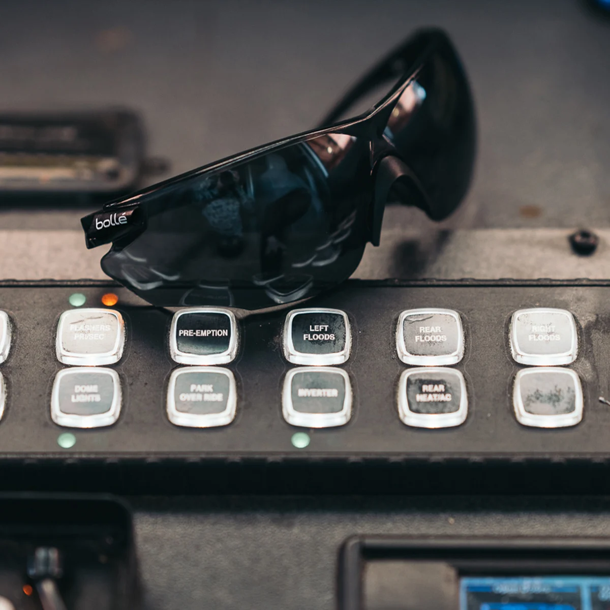 Bolle Combat Ballistic-Rated Safety Glasses 3-Lens Kit with Smoke Gray Lenses installed sitting on a switch panel