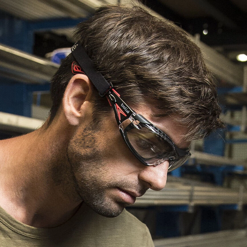 Bolle Rush Plus Safety Glasses Black/Red, Foam Gasket, with Clear Platinum Anti-Fog Lens worn by worker to protect their eyes from airborne dust and debris