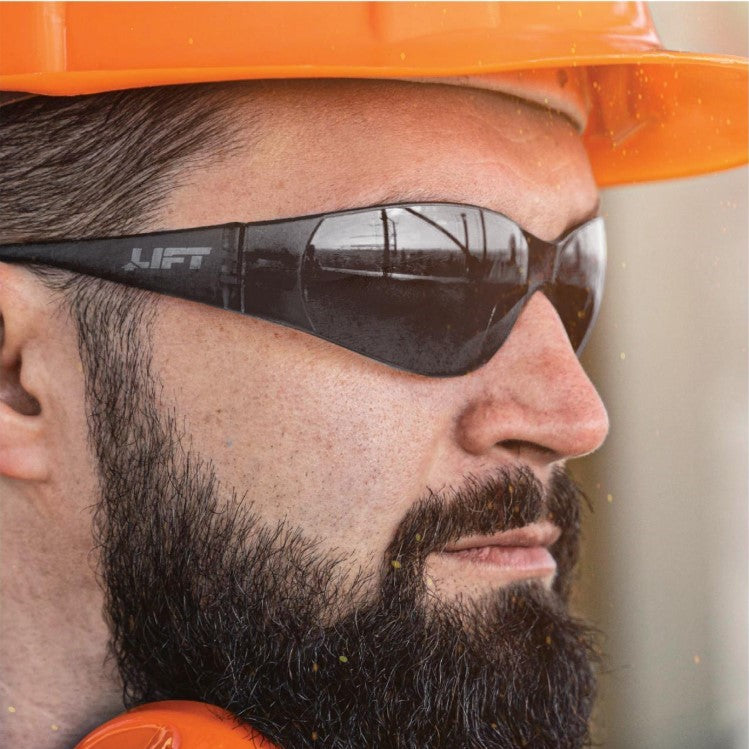 Construction worker wearing LIFT Safety Tear-Off Safety Glasses with Gray Lenses and an Orange Hard Hat
