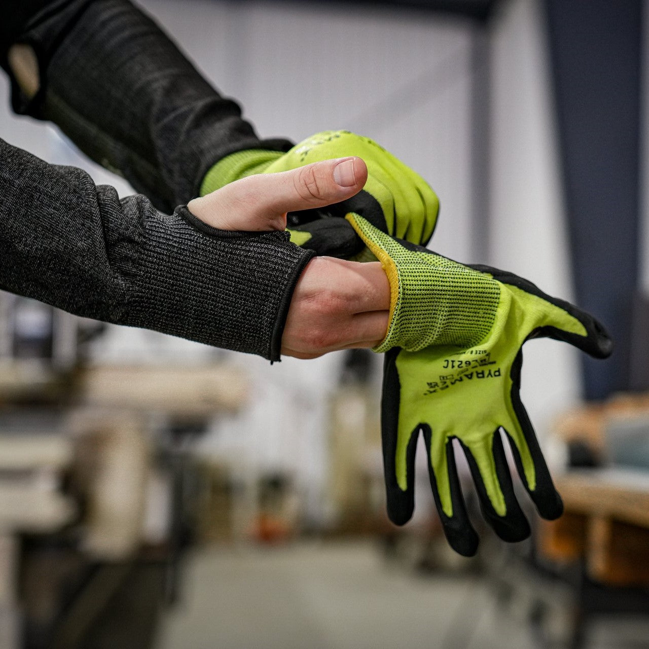 Worker donning Pyramex GL621C A5 Cut-Resistant Micro-Foam Nitrile Gloves