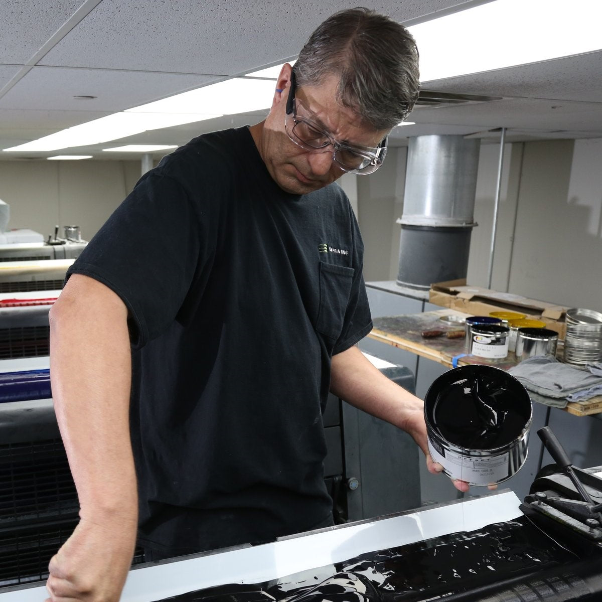 Pyramex OTS XL Safety Glasses Black Temples Clear Lens worn over prescription frames by worker